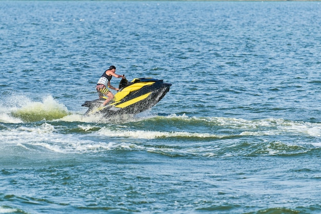 Mann auf Wasserscooter. Sommerferien auf persönlichem Wasserfahrzeug im tropischen Meer