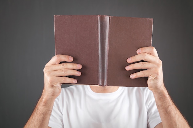 Mann bedeckte sein Gesicht mit einem Buch.