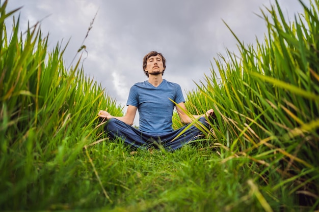 Mann beim Yoga in einem Reisfeld