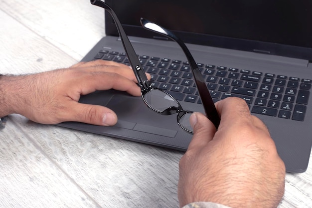 Mann benutzt Laptop mit Stift auf dem Tisch, Nahaufnahme