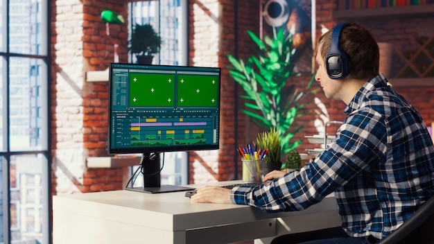Mann benutzt Maus, um Filmprojektmaterial auf einem Chroma-Key-PC zu bearbeiten