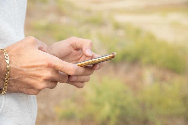 Mann benutzt Smartphone im Freien