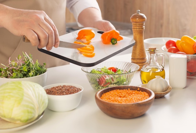 Mann bereitet gesundes vegetarisches Essen auf dem Tisch in der Küche zu