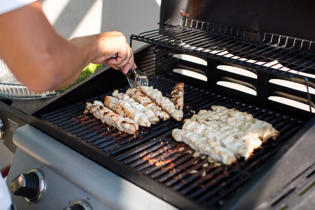 Mann bereitet Grill im Freien vor