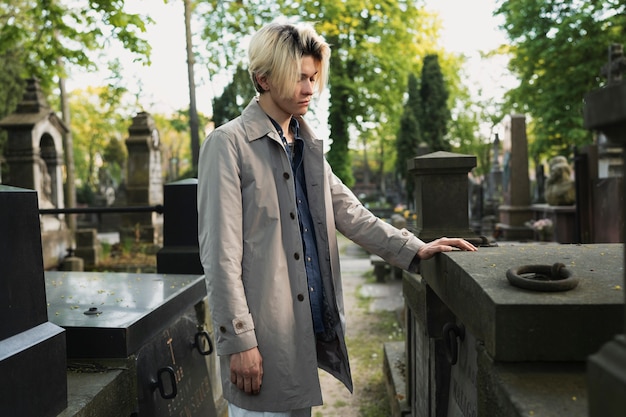Mann besucht ein Grab auf dem Friedhof