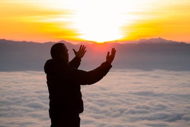 Mann betet bei Sonnenaufgang