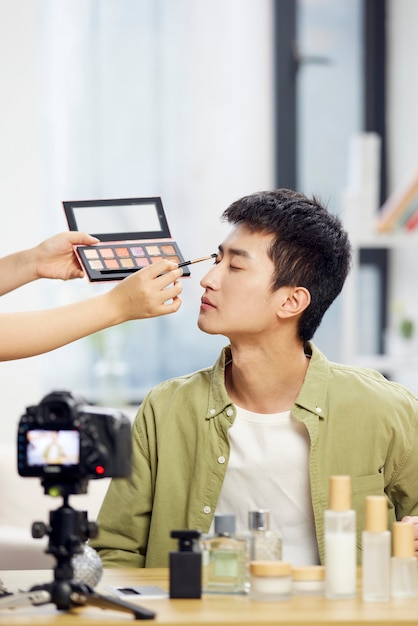 Foto mann blogger zeigt kosmetikprodukt für internet-vlog