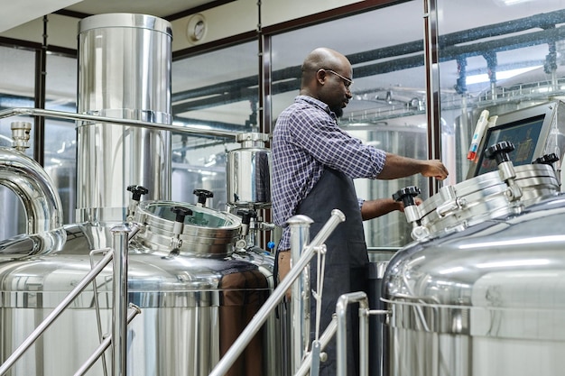 Mann braut Bier in der Werkstatt