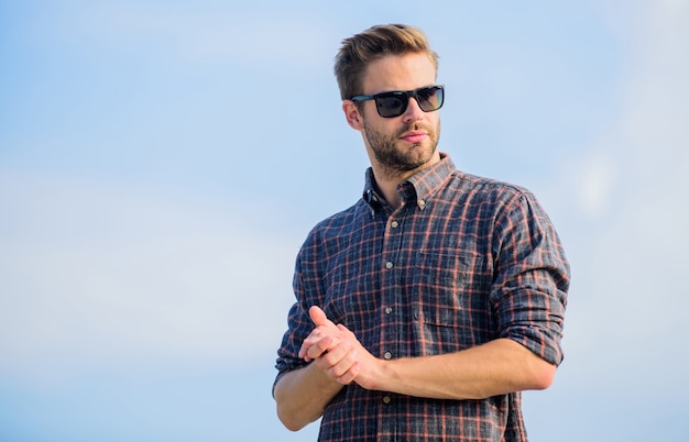 Mann Brillen Modell im Freien Hintergrund des blauen Himmels. Gut aussehender Kerl trägt eine Sonnenbrille. Perfekte Sicht. Gesundheit der Augen. Modische Sonnenbrille. Hipster-Mann in trendiger Sonnenbrille. Ultraviolett-Schutzkonzept.