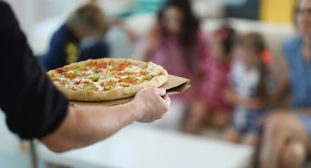 Mann, bring heiße große Pizza mit Füllung und Sauce
