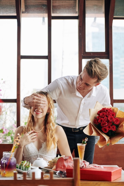 Mann bringt Blumen zur Freundin