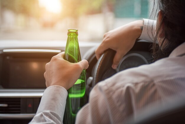 Mann, der Alkohol beim Fahren des Autos trinkt