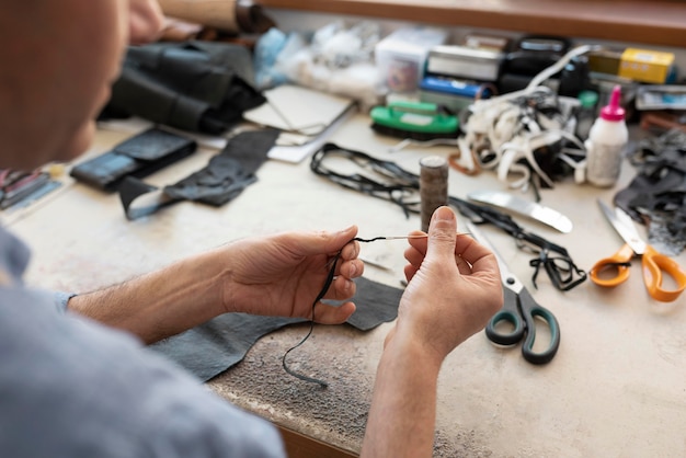 Foto mann, der allein an einer lederwerkstatt arbeitet