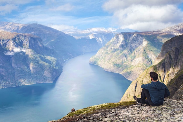 Mann, der allein auf Klippenrand genießt, der Sommerurlaubsreisen des Rucksacklebensstils der Luftansicht im Freien in Norwegen oben auf schönem Bergblauhimmel genießt