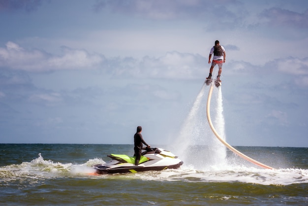 Foto mann, der am extremen wasserfliegenbrett aufwirft.