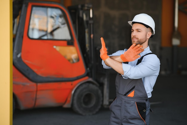 Mann, der am Lager arbeitet und Gabelstapler fährt