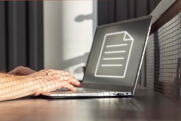 Mann, der am Laptop mit elektronischem Dokument arbeitet, um das Online-Sharing-Konzept für papierlose Arbeitsplätze zu erstellen Hände auf der Tastatur in der Nähe