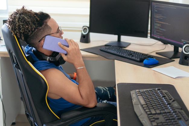 Mann, der am Telefon spricht, während er zu Hause am Tisch sitzt