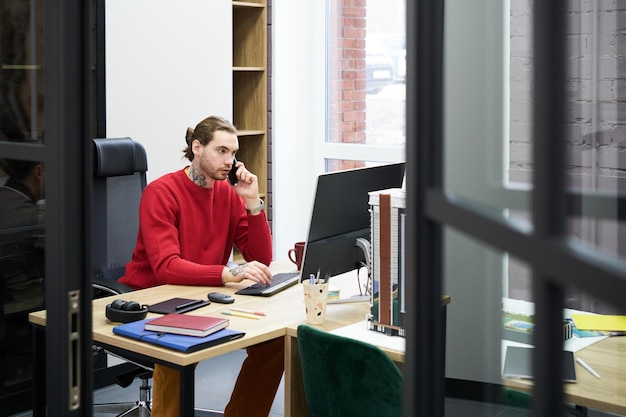 Mann, der an seinem Arbeitsplatz im Büro arbeitet