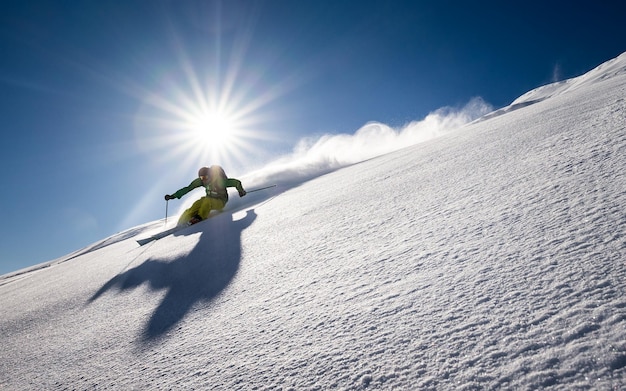 Mann, der auf dem Berg gegen den Himmel Ski fährt