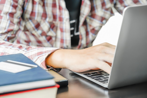 Mann, der auf dem Tisch mit einer Laptop-Computer arbeitet