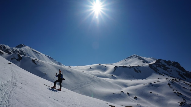 Mann, der auf einem schneebedeckten Berg gegen einen klaren Himmel Ski fährt