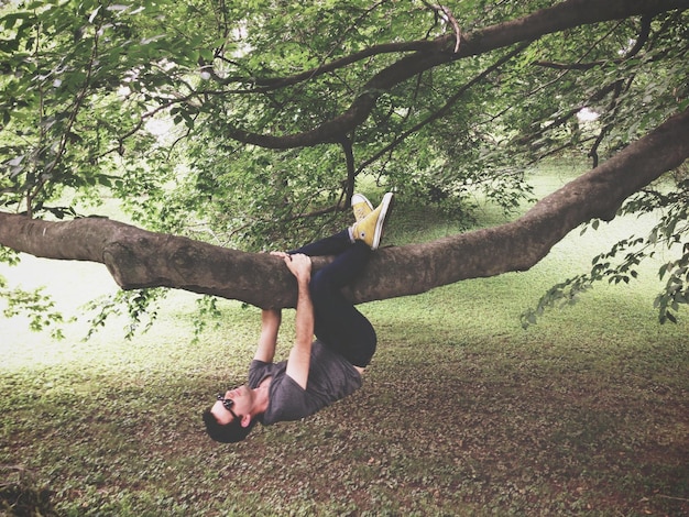 Foto mann, der auf einen baum klettert