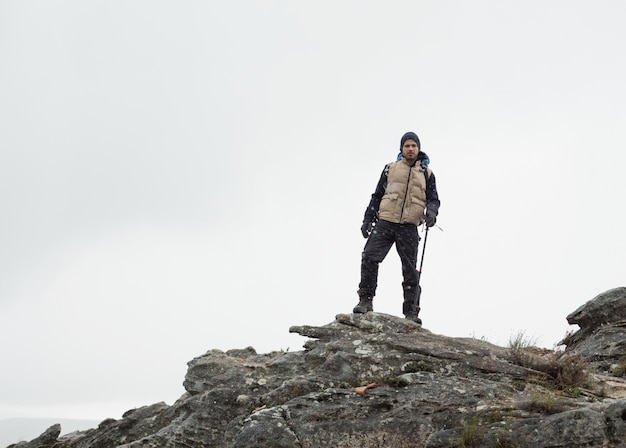 Mann, der auf Felsen gegen den klaren Himmel steht