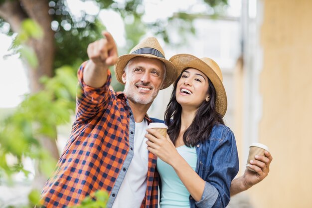 Mann, der auf Frau mit Kaffee zeigt