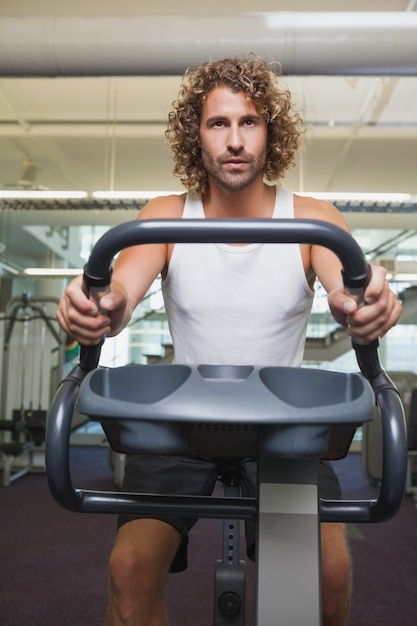 Mann, der auf Hometrainer an der Turnhalle ausarbeitet