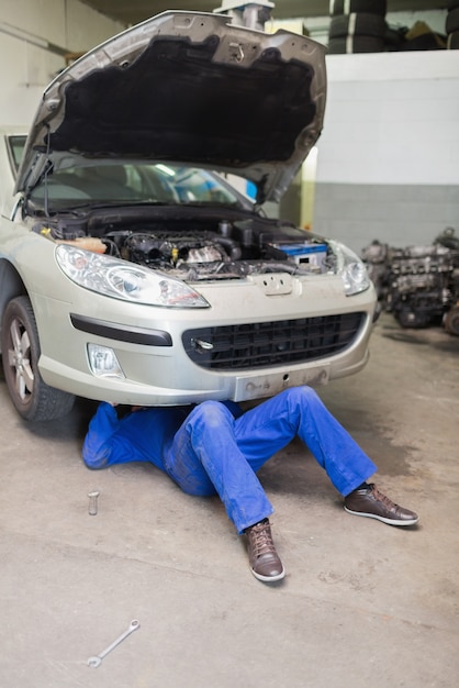 Mann, der Auto in der Garage repariert