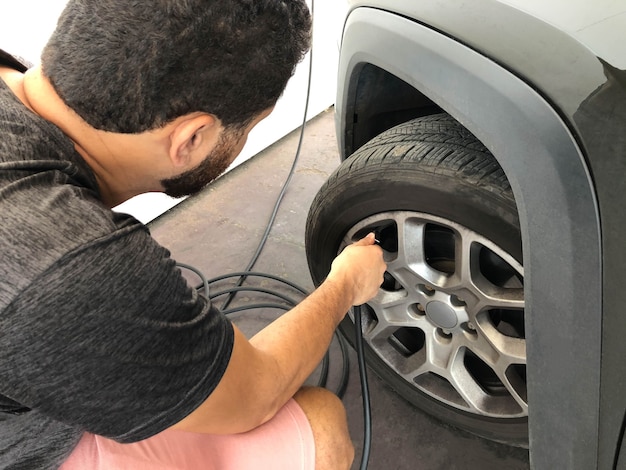 Foto mann, der autoreifennahaufnahme auf hand kalibriert