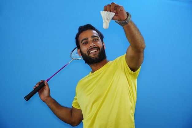 Mann, der Badminton spielt, isoliert auf blauem Hintergrund