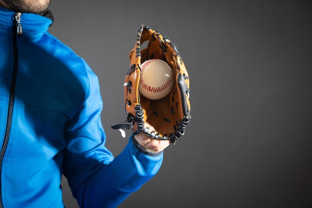 Mann, der Baseballball und Lederhandschuh zeigt