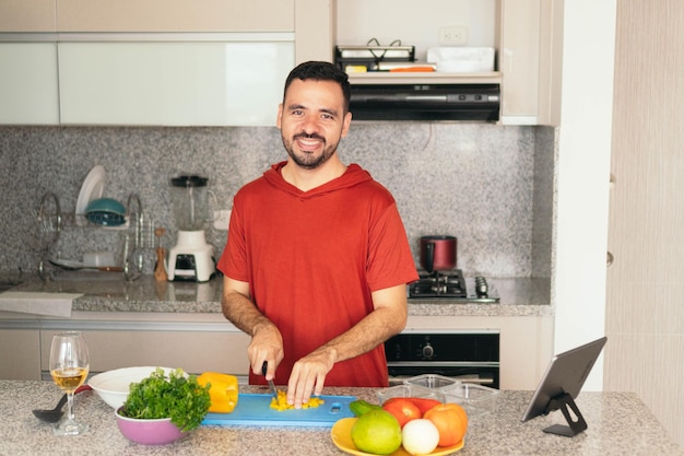 Mann, der beim Kochen im Haus einen Videoanruf tätigt