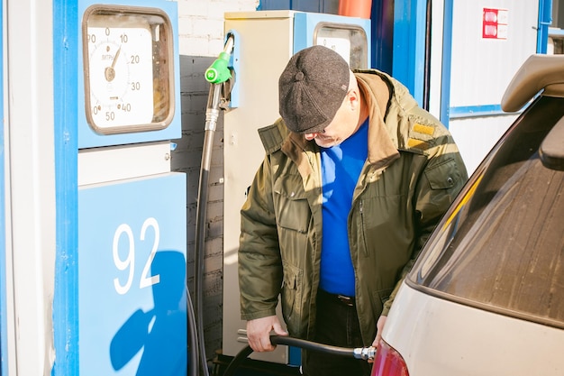 Foto mann, der benzin in seinem auto tanken lässt