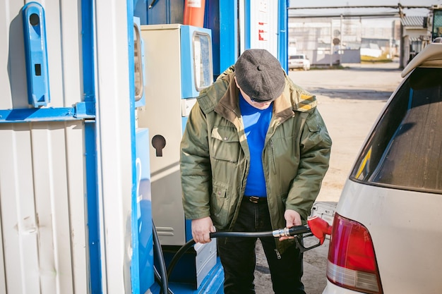 Foto mann, der benzin in seinem auto tanken lässt