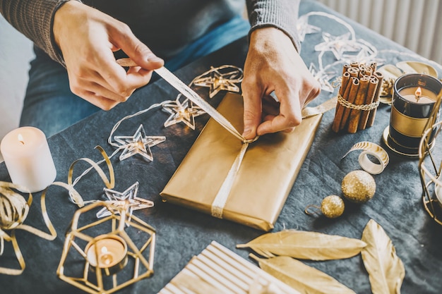 Mann, der Bogen vom Band auf Geschenk macht