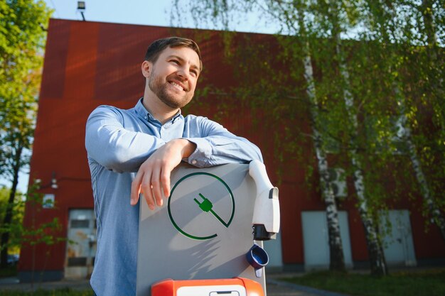 Mann, der das Ladekabel für Elektroautos hält