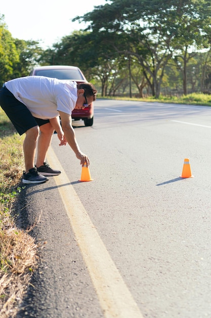 Mann, der das Verkehrsschild mit orangefarbenem Kegel aufstellt