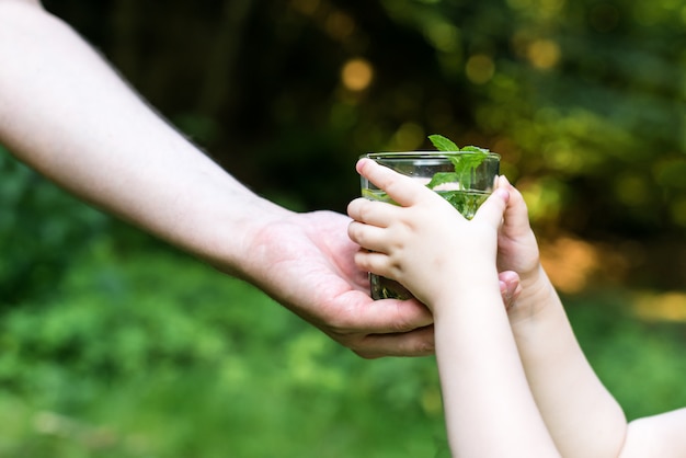 Mann, der dem Kind Wasser gibt