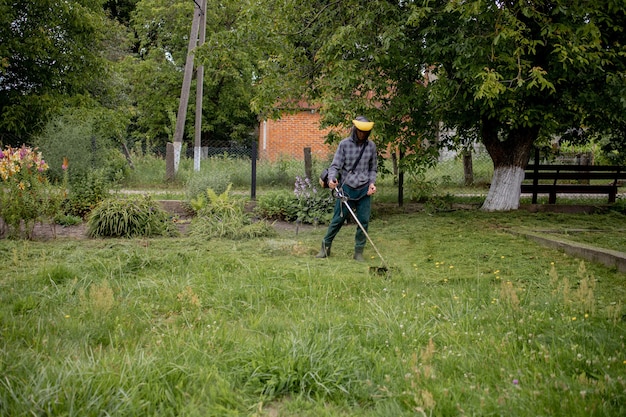 Mann, der den Rasen in seinem Garten mäht. Gärtner schneidet das Gras. Lebensstil.