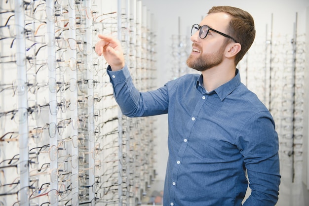 Mann, der die Qualität der Brille im Optikergeschäft bewertet