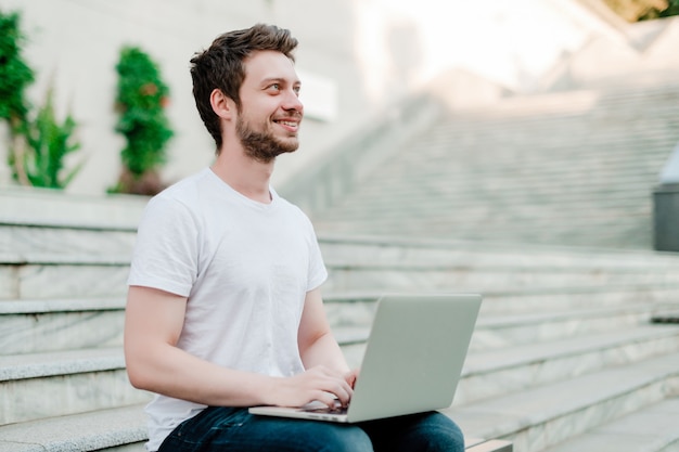 Mann, der draußen Laptop verwendet