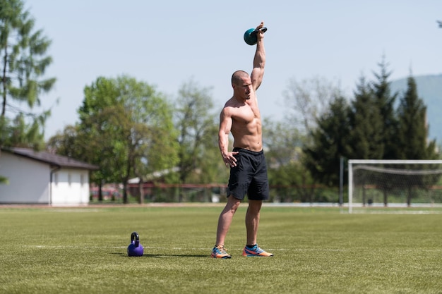 Mann, der draußen mit Kettle Bell trainiert