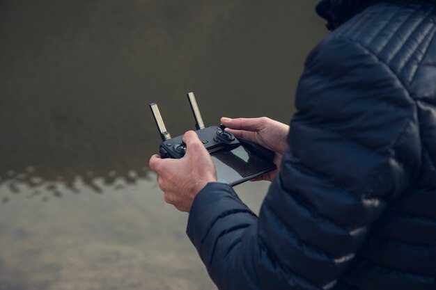 Mann, der drohne im see hält