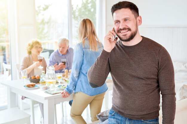 Foto mann, der durch smartphone zu hause spricht