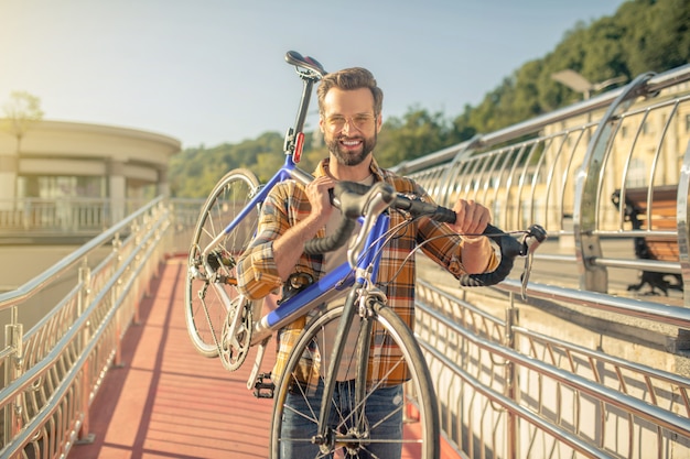 Mann, der ein Fahrrad auf seiner Schulter trägt