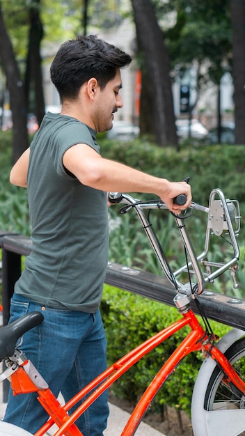 Mann, der ein Fahrrad in einem Park nimmt.