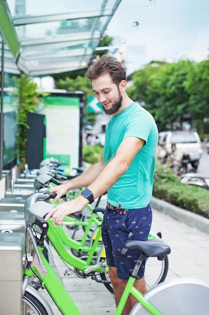 Mann, der ein Fahrrad mietet, um in die Stadt zu pendeln